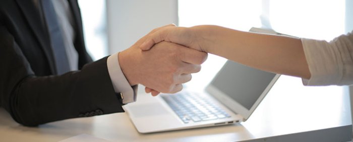 two professionals in front of a laptop, symbolizing trust and customer relationship at the core of Sofrecom’s digital transformation strategy.
